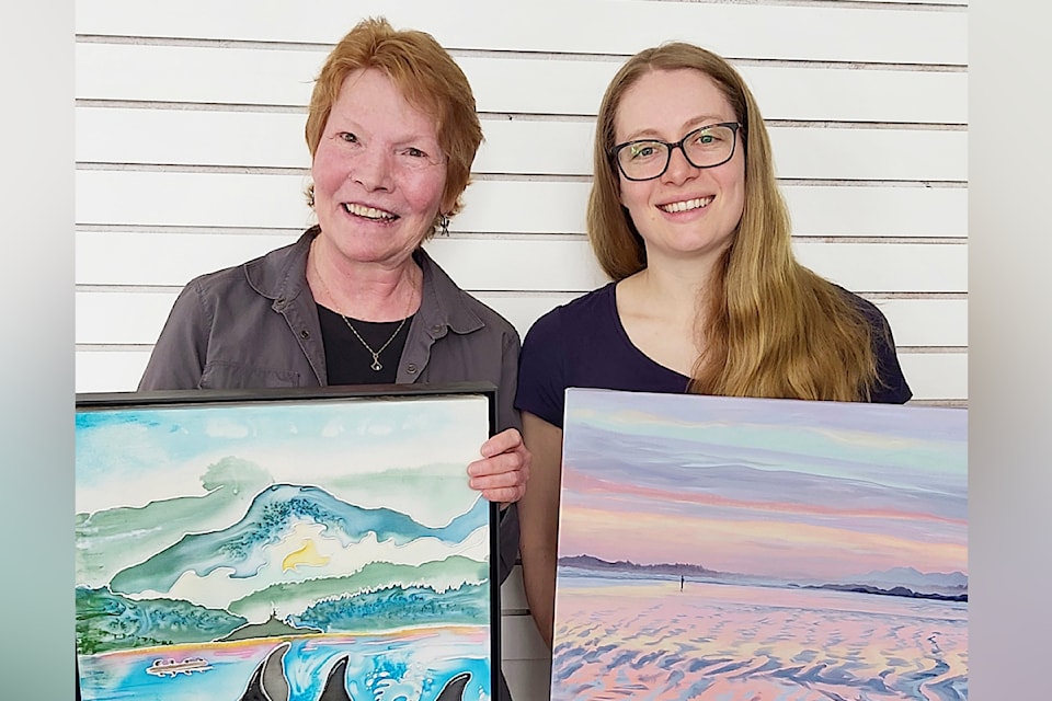 Dianne Nelson and a fellow artist with coastal paintings.